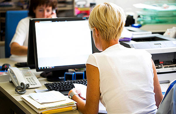 Frau arbeitet am Computer, Bebilderung der Effizienz-Tipps für Computer am Arbeitsplatz.
